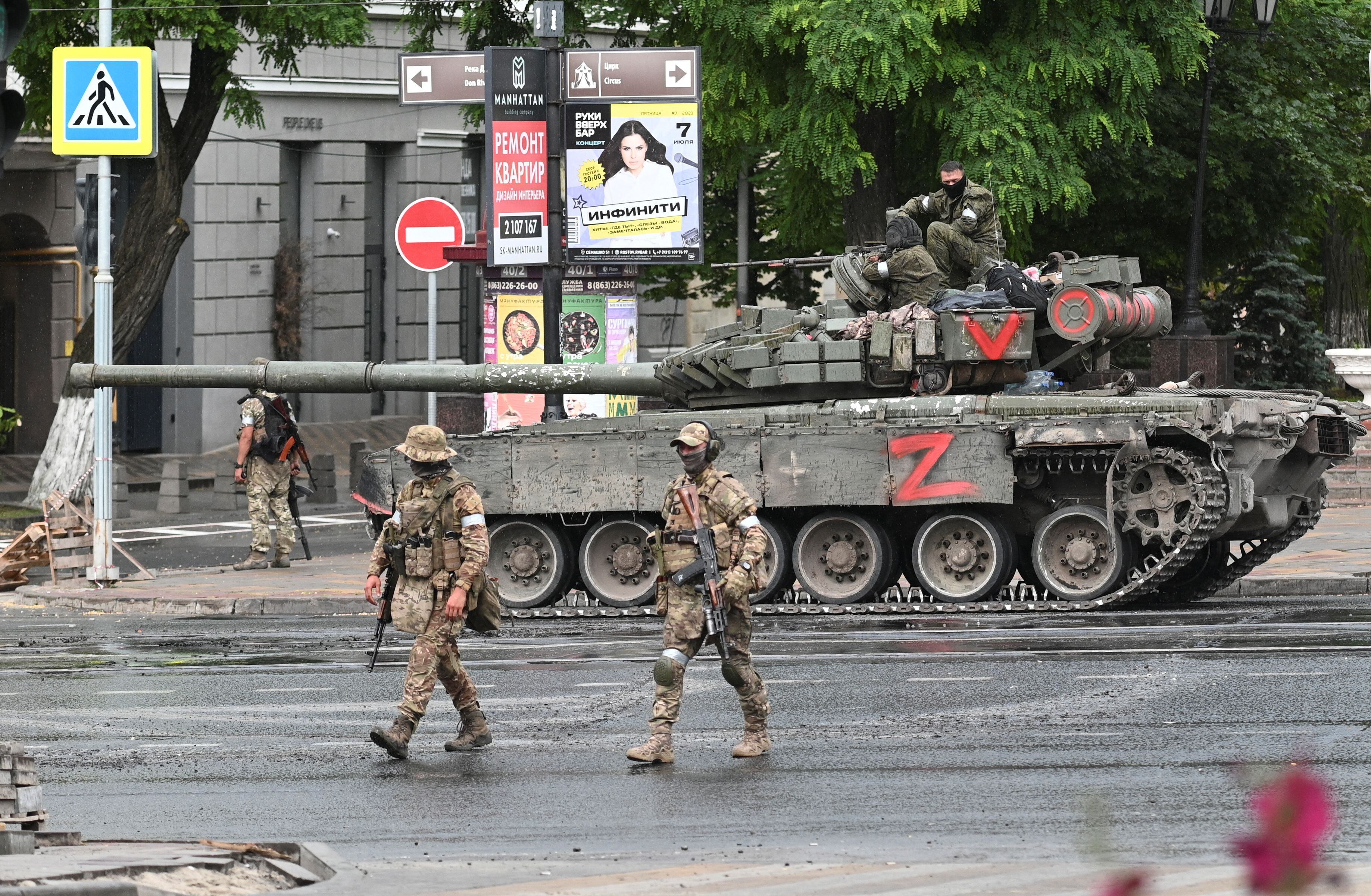 Dos miembros de Wagner pasan ante un tanque de la empresa de mercenarios en la ciudad de Rostov, este sábado.
