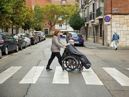 La auxiliar de ayuda a domicilio Mercedes Molina, de 57 años, acompaña a la usuaria Nicolasa Santana, de 92, a un centro de día en Valladolid.