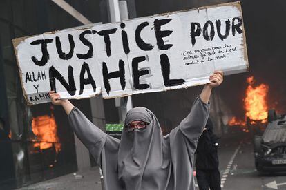 Una mujer sujeta un cartel donde se puede leer 'Justicia para Nahel', durante la protesta en Nanterre, este jueves. 