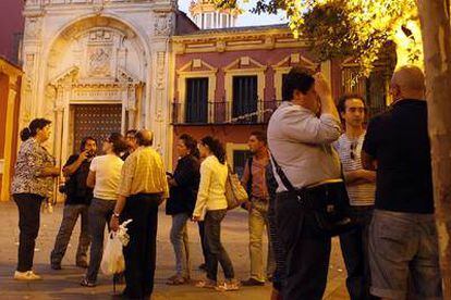 Un grupo de personas ayer frente a la puerta cerrada de la basílica del Gran Poder en Sevilla.