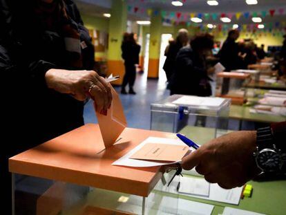 Varios electores depositan sobres con las papeletas en el CEIP Ortega y Gasset de Madrid. EFE/David Fernández