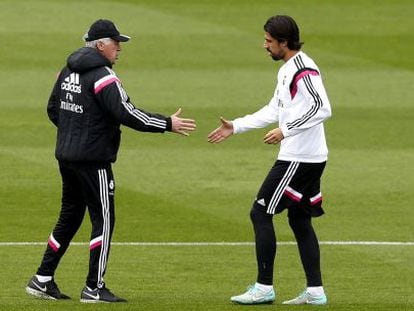 Carlo Ancelotti tiende la mano a Sami Khedira durante el entrenamiento de este mi&eacute;rcoles en Valdebebas. 