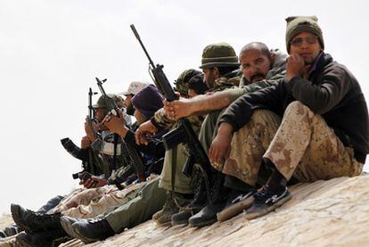 Grupo de rebeldes observan el fuego de artillería de las fuerzas leales a Gadafi, cerca de Brega, en el este de Libia, el 6 de abril de 2011.