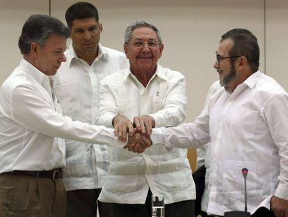 Santos y Timochenko se dan la mano ante Ra&uacute;l Castro.