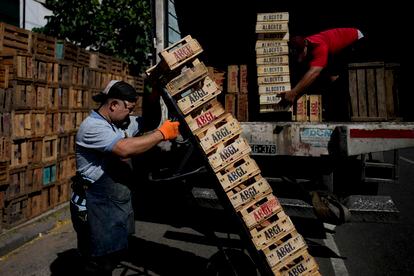 Trabajadores cargan cajas para ir a abastecerse de productos en el mercado central, el 11 de diciembre.