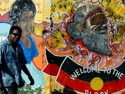 Un aborigen australiano pasa por delante de un mural de arte ind&iacute;gena en Redfern, un barrio perif&eacute;rico de Sidney. 