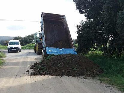 Un camión vuelca arena para cerrar uno de los accesos de Setenil de las Bodegas (Cádiz).