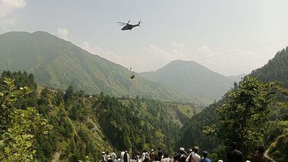Rescate en helicóptero de uno de los menores de edad, del grupo de ocho personas, que este lunes quedó atrapado en un teleférico en Pakistán.
