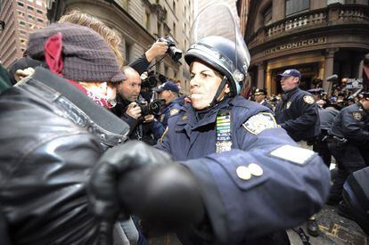 Una agente de policía zarandea a un manifestante durante un acto de protesta del movimiento "Ocupa Wall Street" cerca de la Bolsa de Nueva York.