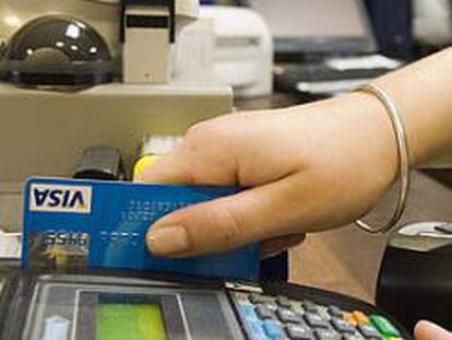 Una dependienta efectúa un cobro con tarjeta de crédito en un establecimiento.