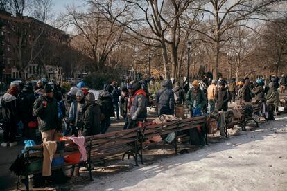 Migrants gather around sites where food and warm clothing are distributed on January 20 in New York.