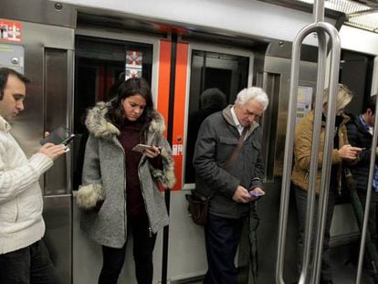 Viajeros del Metro de Bilbao consultan sus móviles.