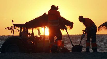 Operarios del Ayuntamiento de Valencia limpian la playa de la Malva-rosa tras la Noche de San Juan. 