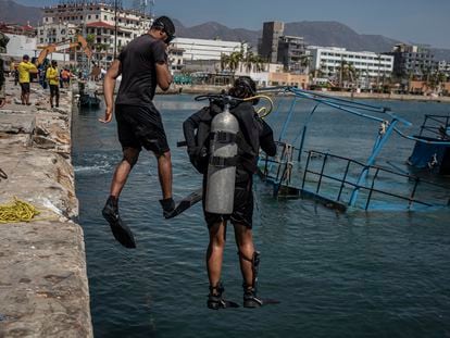 Buzos de la Marina se arrojan al mar durante las labores para sacar una embarcación en Acapulco.