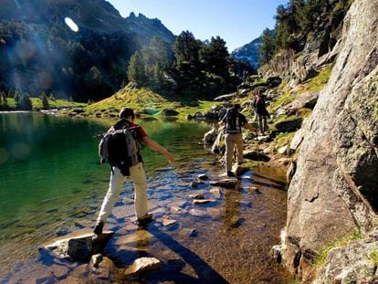 Senderistas en el lago Redon, dentro del parque nacional de Aigüestortes i Estany de Sant Maurici, en el Valle de Arán (Lleida).