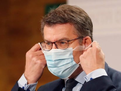 El presidente de la Xunta, Alberto Núñez Feijóo, se quita la mascarilla a su llegada a una rueda de prensa este viernes en Santiago de Compostela.