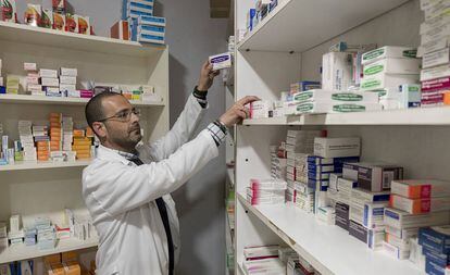 Un farmacéutico dispensa medicamentos en una farmacia de Sevilla. 
