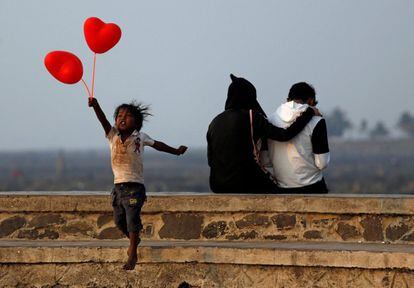 Un niño salta en el paseo de la costa de Bombay después de intentar vender globos en forma de corazón a una pareja por el día de San Valentín (India).