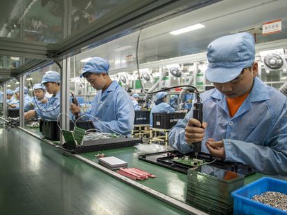 Empleados montan circuitos en una cadena de montaje  en la provincia china de Zhejiang