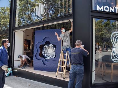 Operarios reparan el escaparate de la joyería Montblanc de paseo de Gràcia, tras sufrir un alunizaje.