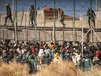 FILE - Riot police officers cordon off the area after migrants arrive on Spanish soil and crossing the fences separating the Spanish enclave of Melilla from Morocco, in Melilla, Spain, June 24, 2022. Spain’s interior minister, Fernando Grande-Marlaska, is coming under increased pressure to be more transparent about how Spanish security forces responded to a June incident at its border with Morocco that led to the deaths of at least 23 migrants in the North African enclave of Melilla. (AP Photo/Javier Bernardo, File)