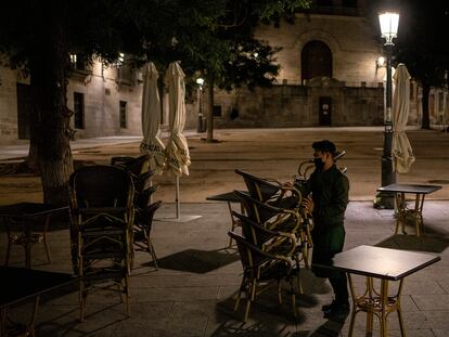 Un camarero recoge la terraza de un bar en la plaza de la Paja de Madrid.