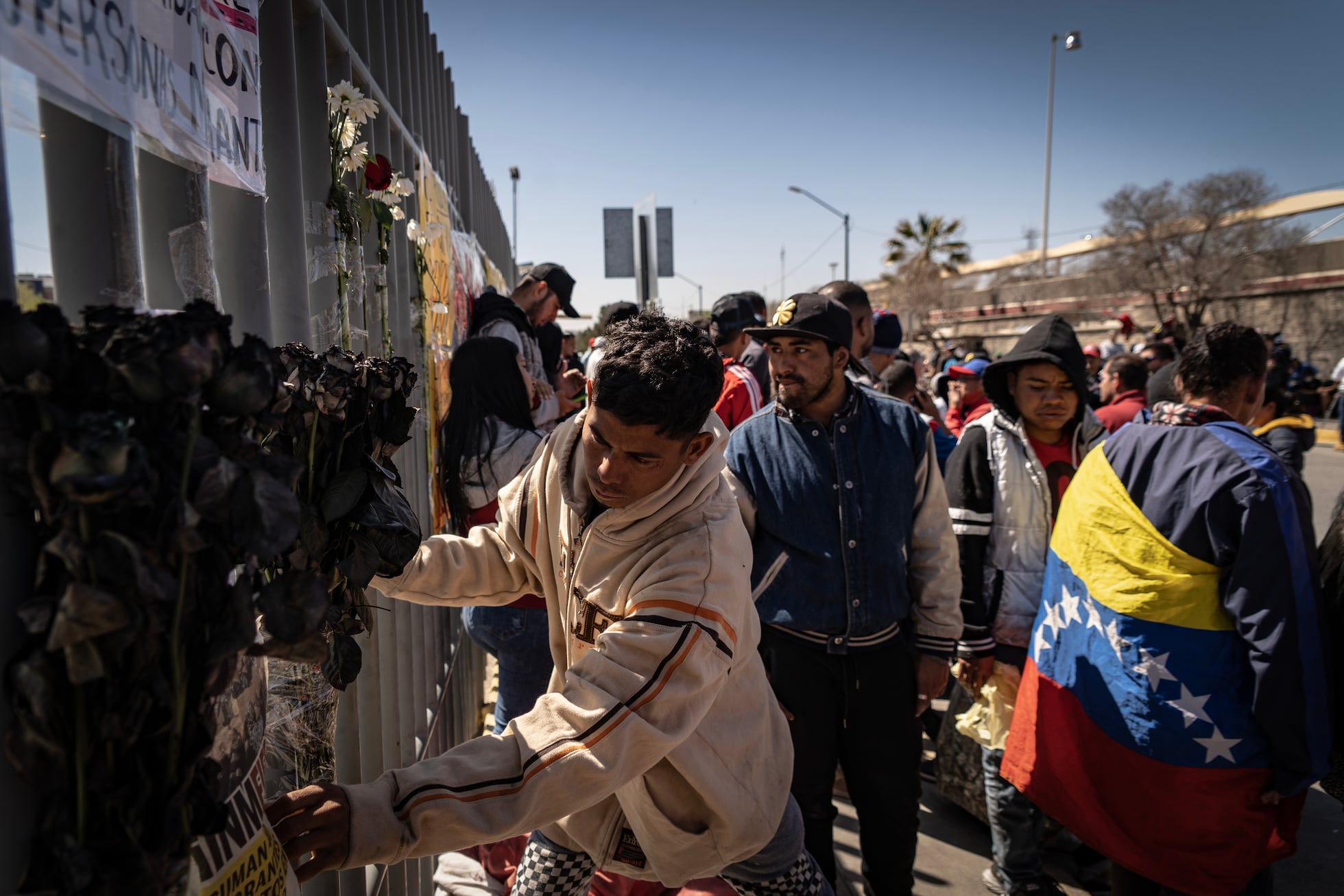 Migrantes colocan flores en el altar dedicado 38 fallecidos durante el incendio de pasado lunes en el INM. 