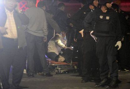 Una víctima es examinada después de que un grupo de personas con cuchillos atacara a la gente, ayer, en la estación de Kunming (China).
