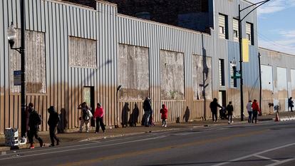 Personas caminan afuera de un refugio para migrantes en Chicago, en diciembre 2023.