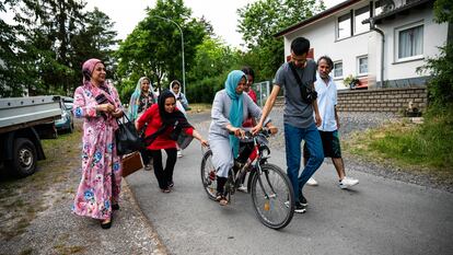 Sima Rahmati, refugiada afgana en Fulda, Alemania, intenta aprender a andar en bicicleta con la ayuda de sus hijos, adoptando así una de las costumbres occidentales.