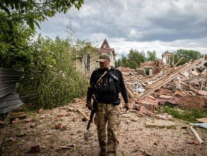 Un combatiente de las Fuerzas de Defensa Territorial, frente a un edificio bombardeado en las afueras de la provincia de Donetsk, en Donbás.