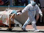 A health worker wearing personal protective equipment (PPE) carries a patient suffering from the coronavirus disease (COVID-19) outside the casualty ward at Guru Teg Bahadur hospital, in New Delhi, India, April 24, 2021. REUTERS/Adnan Abidi     TPX IMAGES OF THE DAY