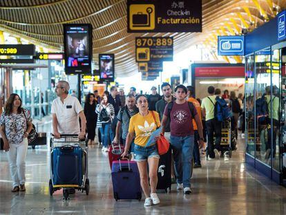 Viajeros transitan por la terminal 4 del aeropuerto de Barajas al inicio de las vacaciones del mes de agosto.