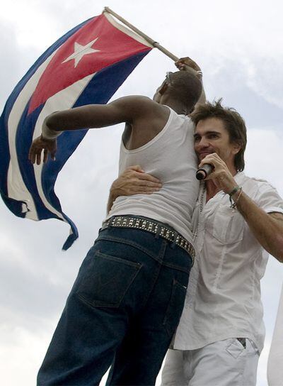 Juanes abraza a un fan cubano durante el concierto <i>Paz sin fronteras</i>.