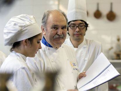 Luis Irizar, en el centro, junto a dos alumnos en su escuela de cocina, en San Sebastián.