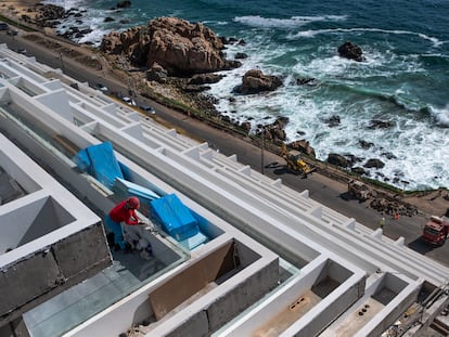 Una trabajadora de la construcción limpia los ventanales de una nueva edificación al costado del borde costero de Valparaíso, el 5 de diciembre de 2022.