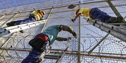 Operarios instalan alambres con cuchillas en la valla de Melilla.