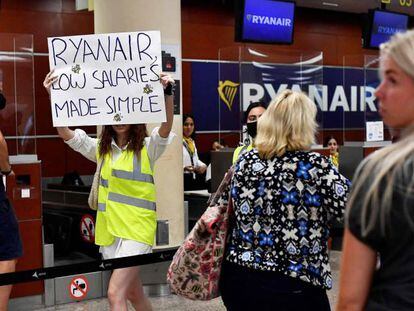 Una empleada de Ryanair protesta ante los puestos de facturación de la low cost en Barcelona-El Prat.