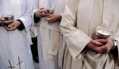 Sacerdotes con cálices durante una misa.