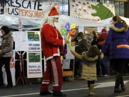 Papá Noel reparte globos frente a los acampados de Bankia.