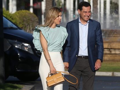 Moreno y su mujer, Manuela Villena, camino de la sede del PP en Sevilla, el domingo por la tarde.