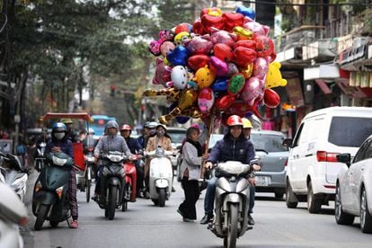 Una vendedora ambulante ofrece globos, en una calle de Hanói (Vietnam). Las flores y los globos son considerados los obsequios más populares que los hombres dan a las mujeres en el Día Internacional de la Mujer en Vietnam, que se conmemora anualmente el 8 de marzo.