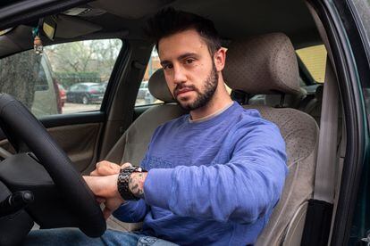 Ernesto Copete, de 26 años, ajusta su reloj dentro de su vehículo, antes de salir a Elvas, Portugal, donde trabaja todos los días.