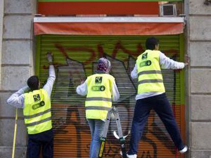 Tres participantes en el plan de limpieza en la calle de Sant Pere m&eacute;s Baix.