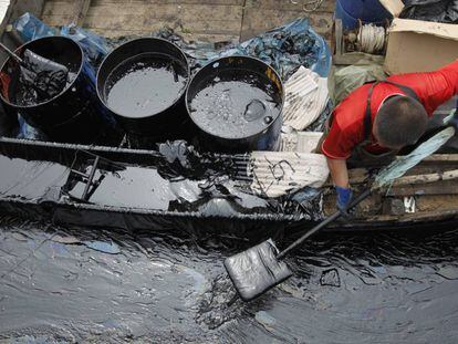 Un pescador recoge crudo en China tras un vertido en 2010.