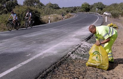 Un empleado de conservación de carreteras limpia los últimos restos del lugar del accidente de Ortega Cano.