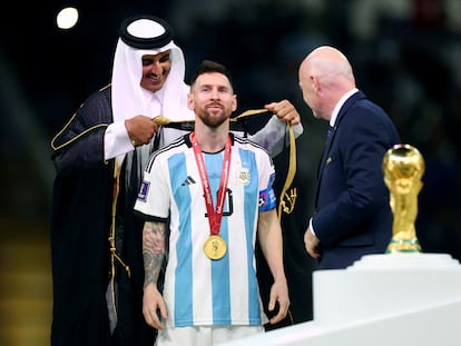 Lionel Messi junto al emir de Qatar, Sheikh Tamim bin Hamad Al Thani, y el presidente de la FIFA, Gianni Infantino, durante la entrega de la Copa del Mundo después de la victoria de Argentina ante Francia en la final del Mundial, en el estadio Lusail este domingo.