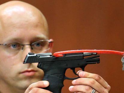 Un polic&iacute;a sujeta la pistorla con la que Zimmerman mat&oacute; al joven Trayvor Martin en 2013.