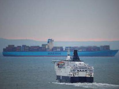 Ferry DFDS en primer plano y barco contenedor de Maersk al fondo, en Dover (Reino Unido).