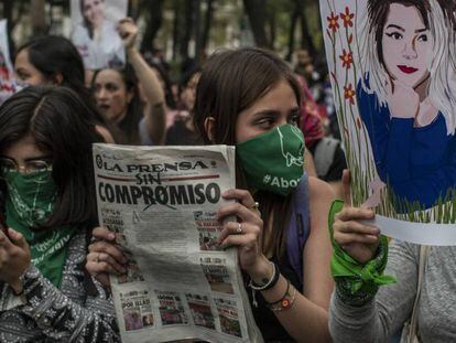 Mujeres marchan con un dibujo de la asesinada y el periódico donde se difundieron las fotos del cadáver.